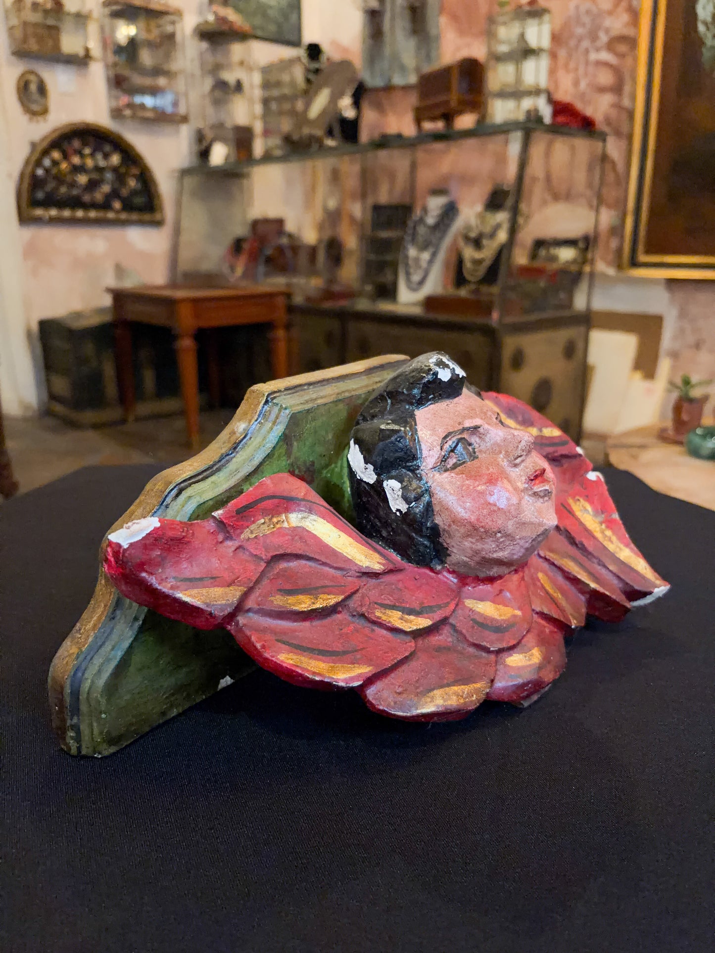 Antique polychrome wood angel shelf bracket with carved cherub, Mexican folk art, wing feathers, overhead detail view