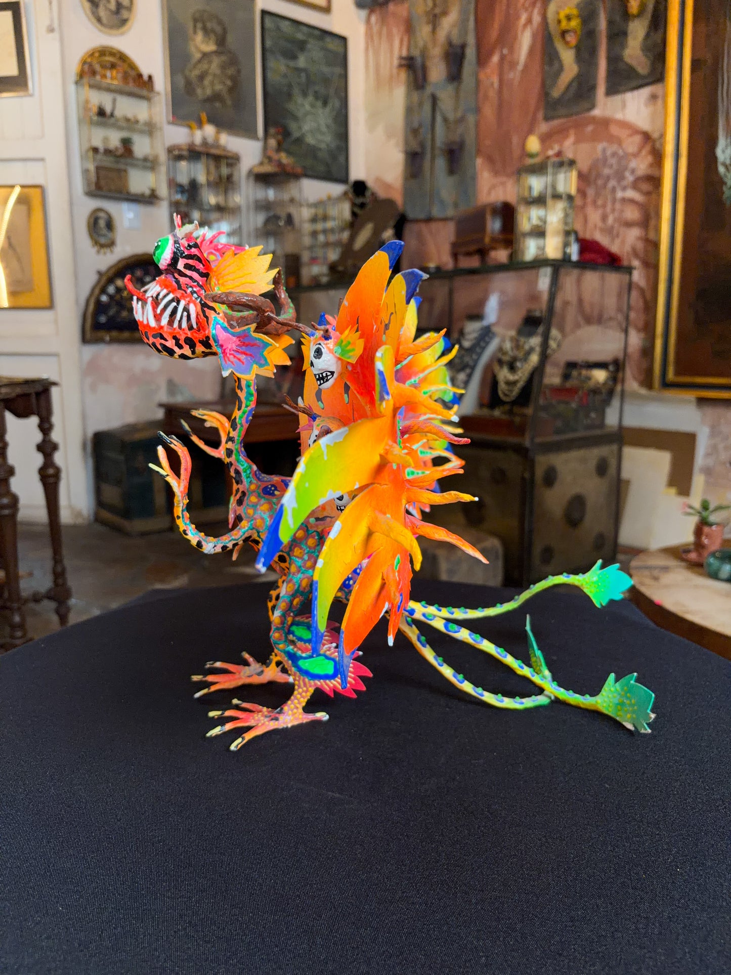 Handcrafted papier-mache alebrije dragon sculpture with skulls figure, Oaxacan Mexican folk art, painted detail, skull motif