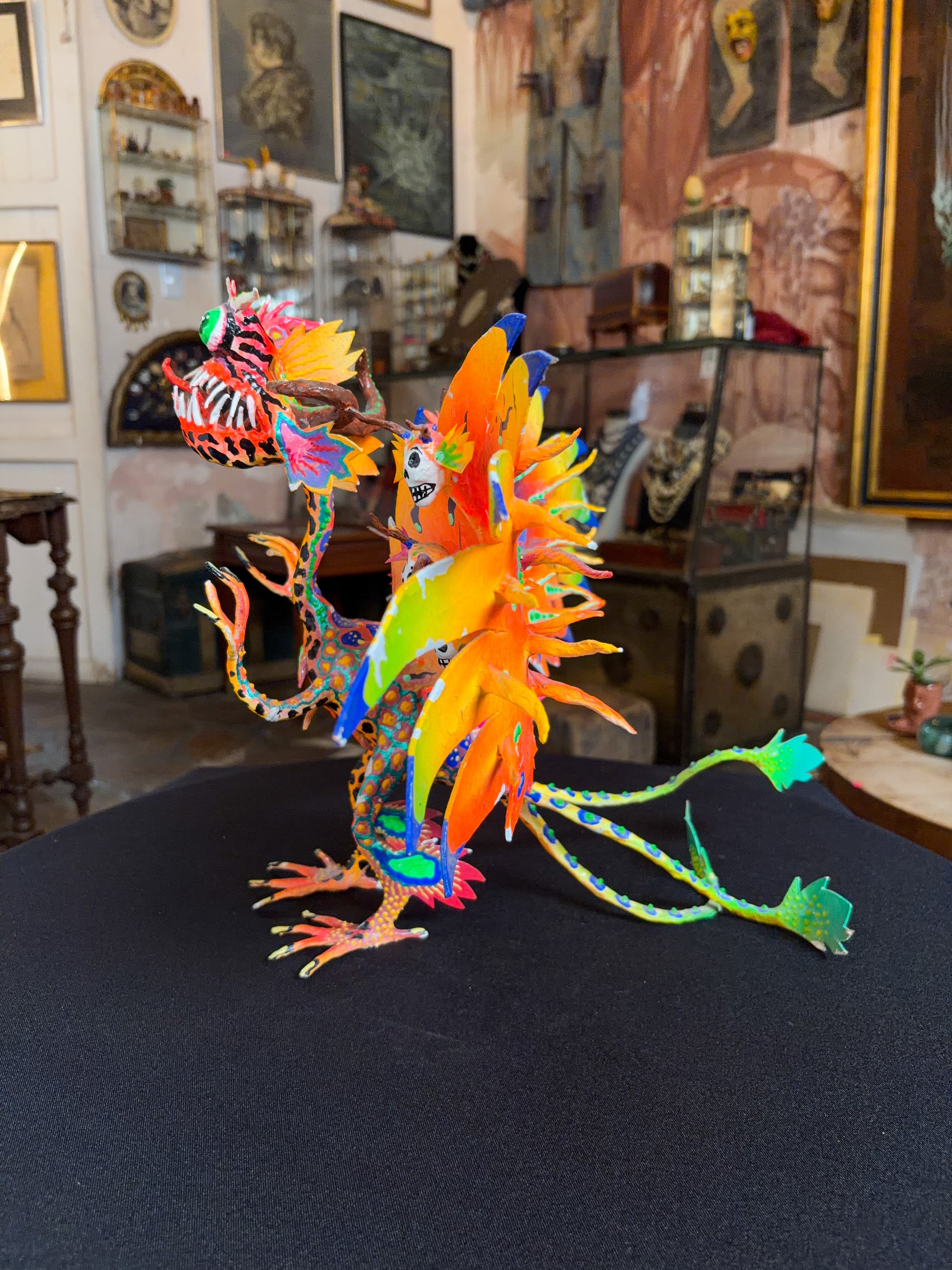 Handcrafted papier-mache alebrije dragon sculpture with skulls figure, Oaxacan Mexican folk art, painted detail, skull motif