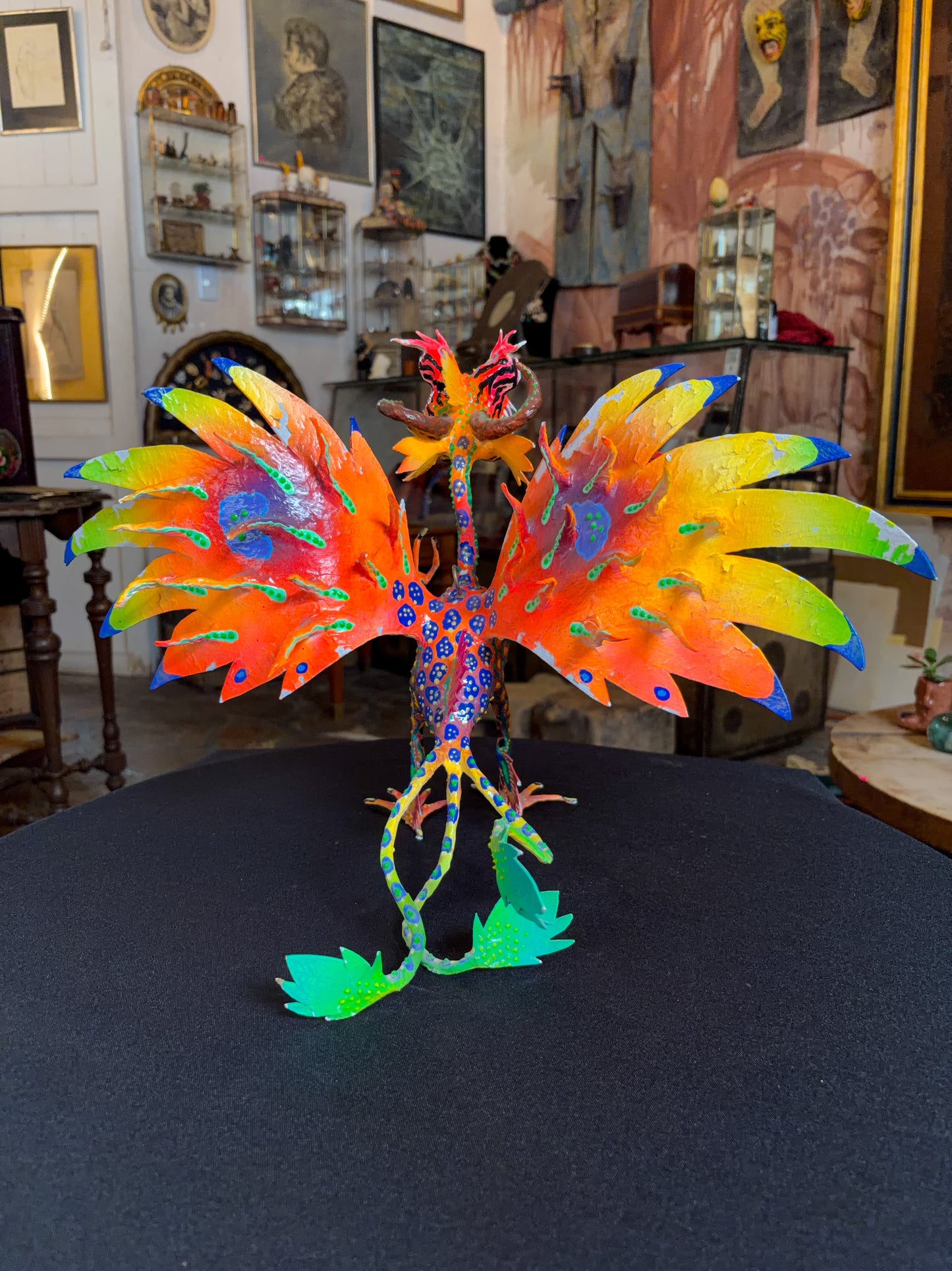 Handcrafted papier-mache alebrije dragon sculpture with skulls figure, Oaxacan Mexican folk art, painted detail, tail