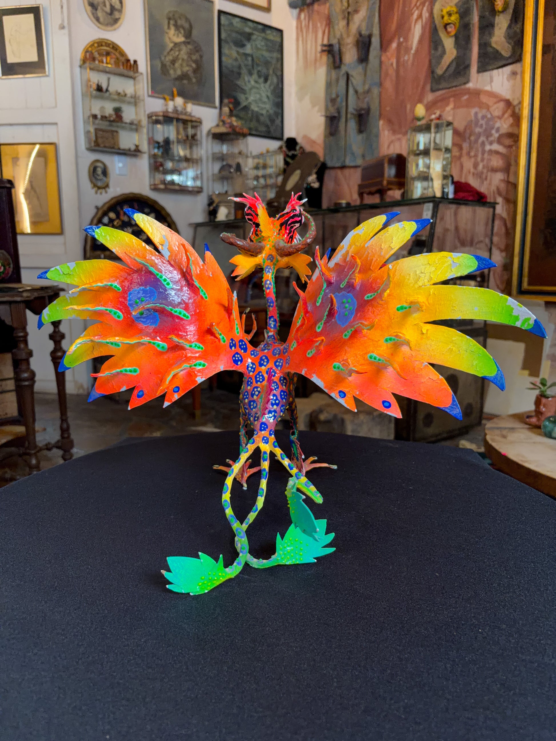 Handcrafted papier-mache alebrije dragon sculpture with skulls figure, Oaxacan Mexican folk art, painted detail, tail