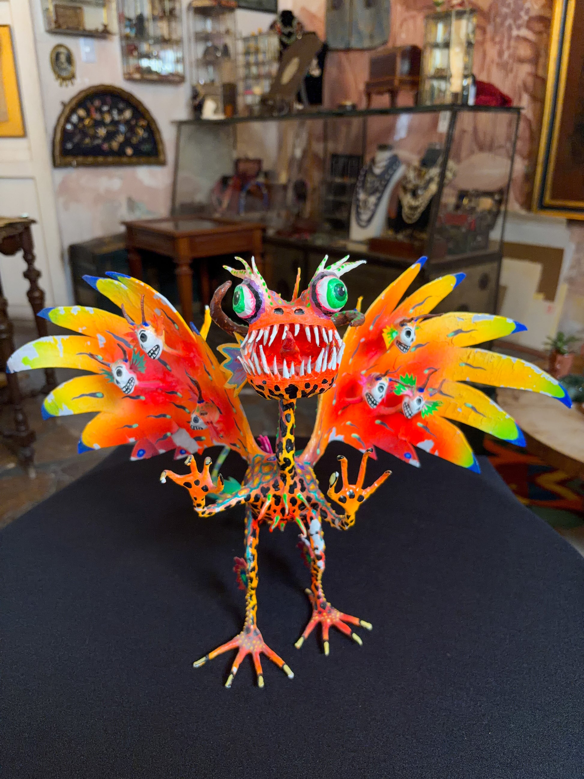 Handcrafted papier-mache alebrije dragon sculpture with skulls figure, Oaxacan Mexican folk art, painted detail, scales