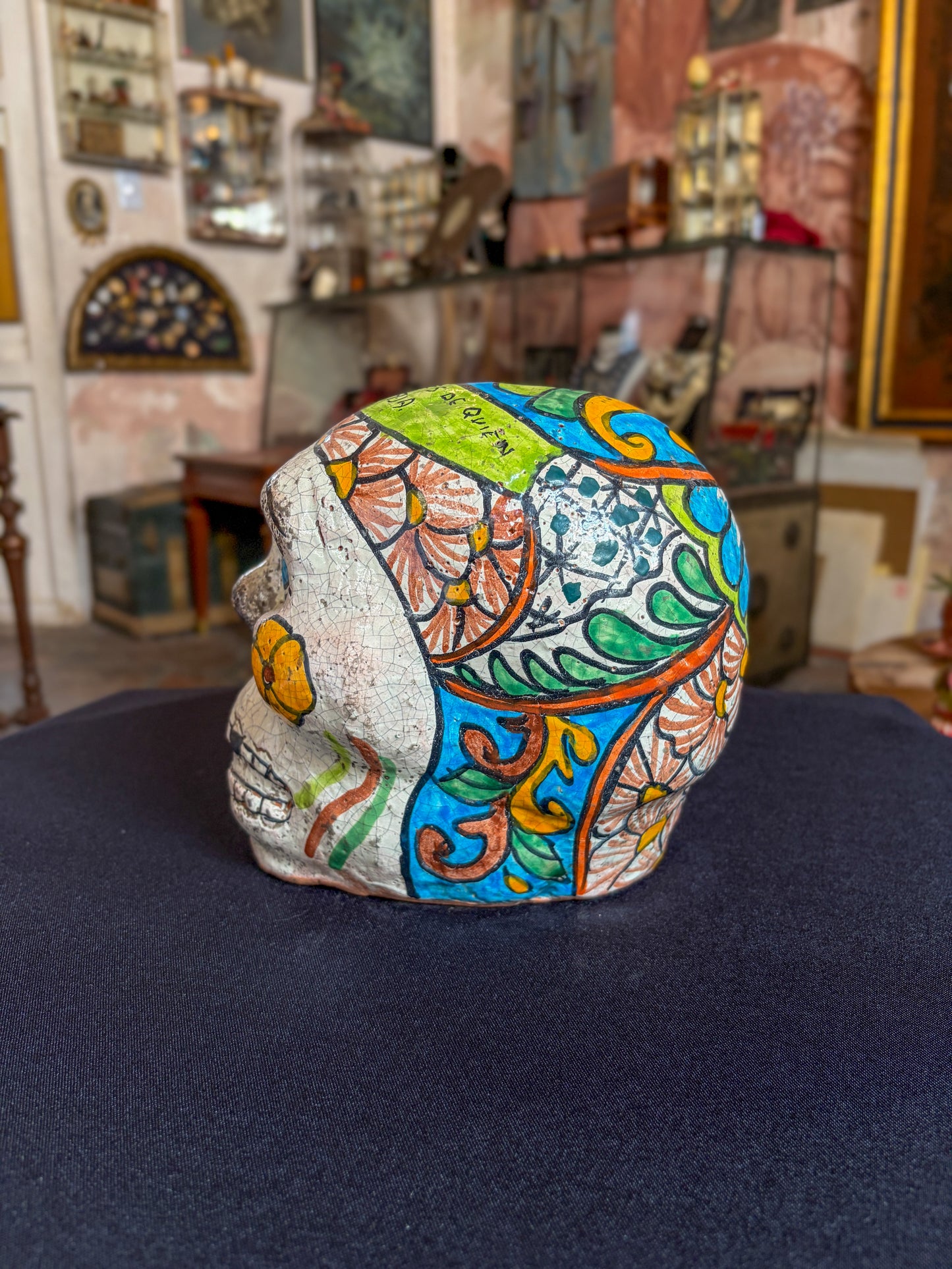 Handcrafted glazed clay skull ornament, Puebla Mexican folk art, right side, floral scroll pattern and artist inscription