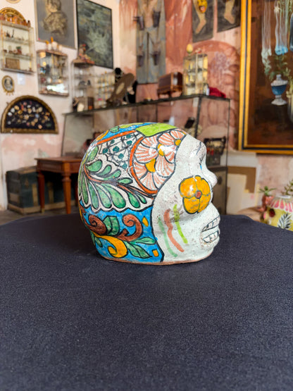 Handcrafted glazed clay skull ornament, Puebla Mexican folk art, left side, blue scroll and leaf pattern